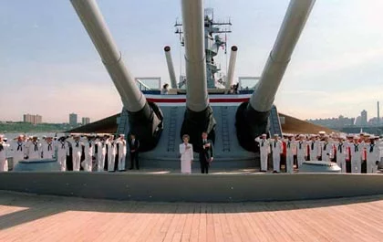 A group of uniformed naval officers stand at attention on the deck of the iconic Battleship USS Iowa with large cannons, while two people stand centered in front, flanked by a patriotic ribbon, evoking the spirit and history showcased at this renowned Los Angeles museum. A group of uniformed naval officers stand at attention on the deck of the iconic Battleship USS Iowa with large cannons, while two people stand centered in front, flanked by a patriotic ribbon, evoking the spirit and history showcased at this renowned Los Angeles museum.