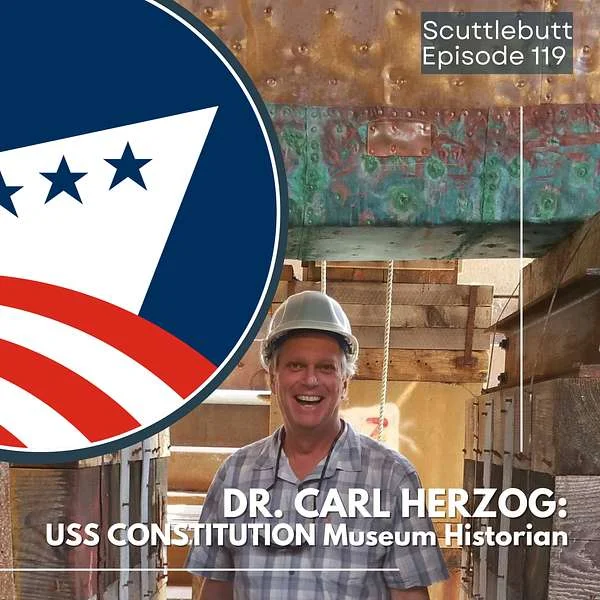 A smiling man in a hard hat stands in front of a ship’s hull. Text reads: Scuttlebutt Episode 119. Dr. Carl Herzog: USS Constitution Museum Public Historian. A logo with stars and stripes is on the left.