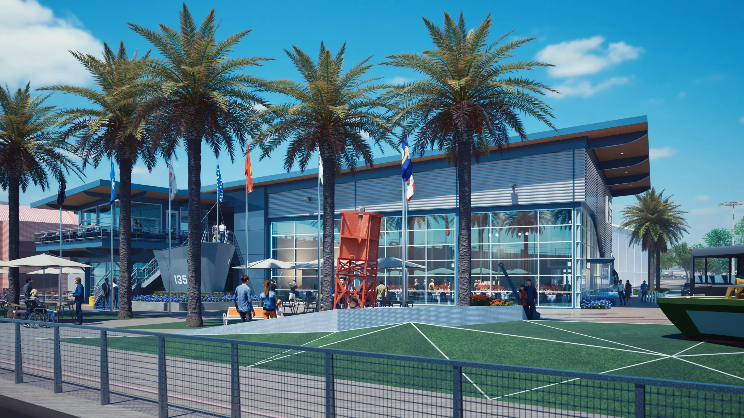 A modern building with large windows, palm trees, people walking and sitting outside, flags, and a green lawn with a metal fence in front under a bright blue sky—this is the vibrant scene at Freedom of the Seas Pavilion.