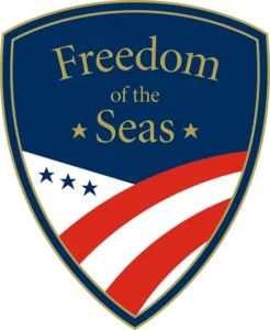 A shield-shaped logo with the text Freedom of the Seas above a waving red, white, and blue design with four blue stars. A shield-shaped logo with the text Freedom of the Seas above a waving red, white, and blue design with four blue stars.