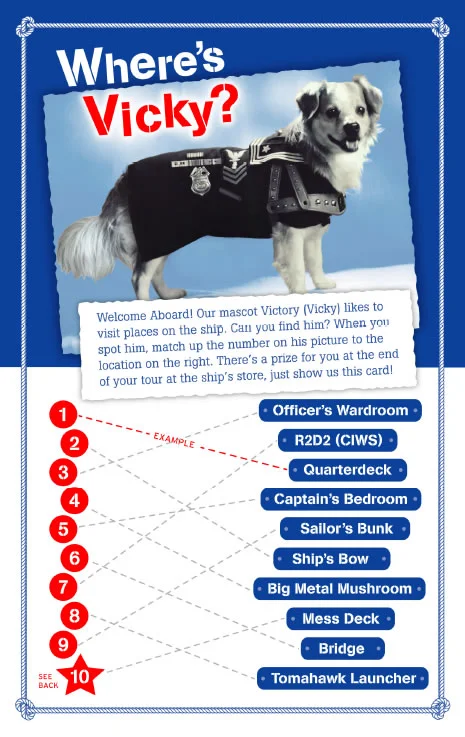 A dog wearing a black jacket sits on a ship-themed game board with numbered circles and a list of ship locations, titled Wheres Vicky? at the top.